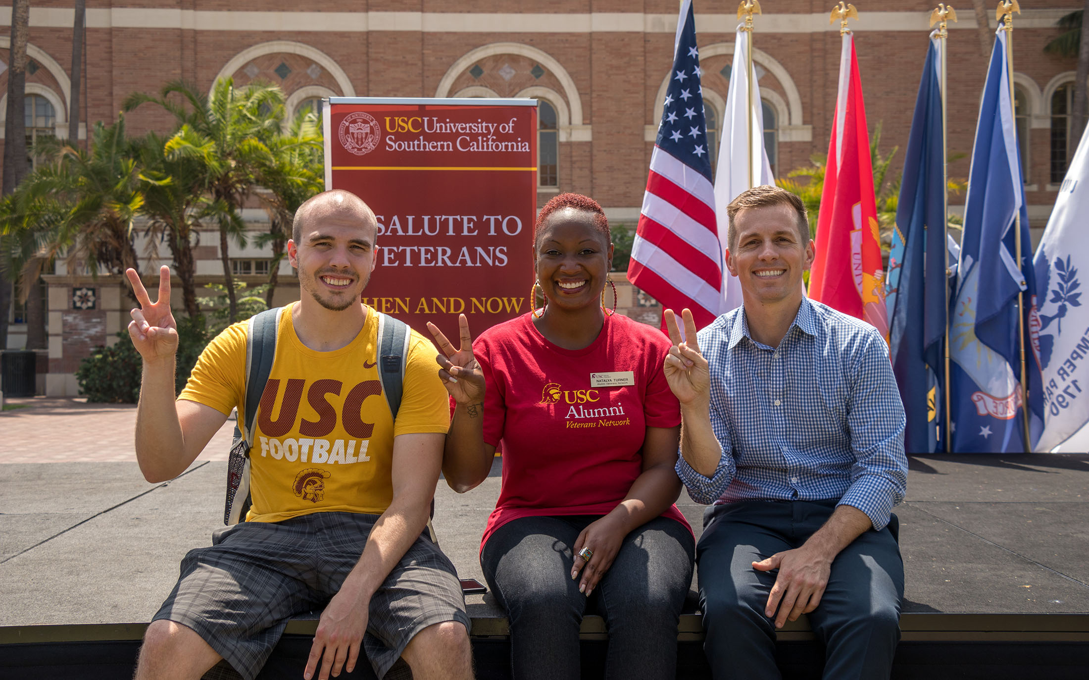 Three people sitting on a stage at USC